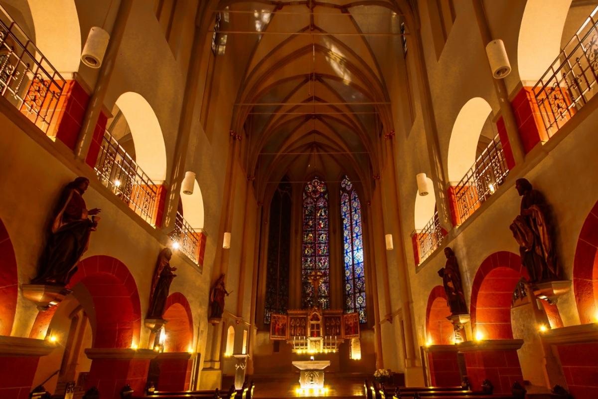 Innenraum der Pfarrkirche Sankt Servatius Siegburg nur durch Kerzenschein erleuchtet.